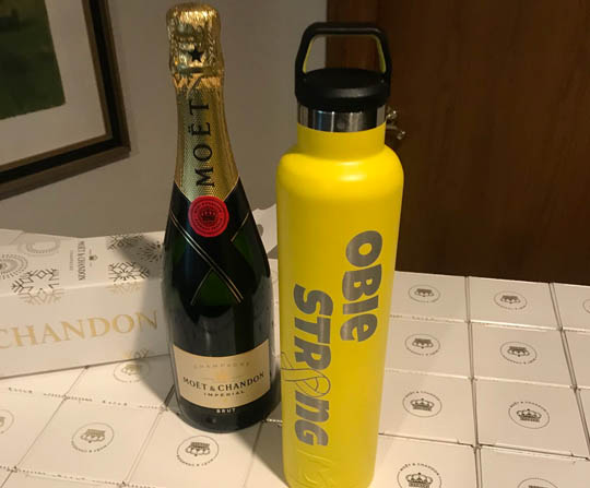 Engraved champagne bottle beside a yellow insulated water bottle