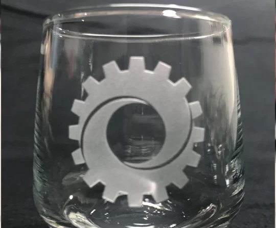 Glass tumbler etched with a company gear logo