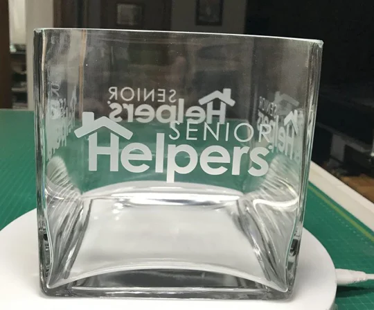 Senior Helpers logo etched into a square glass vase
